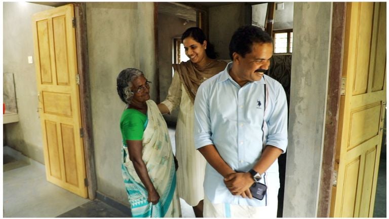 മാരായമുട്ടം ചുള്ളിയൂരില്‍ നിര്‍മിച്ചുനല്‍കിയ വീട്ടില്‍ ജോയിയുടെ അമ്മ മെല്‍ഗിക്കൊപ്പം മേയര്‍ ആര്യ രാജേന്ദ്രനും  ജില്ലാ പഞ്ചായത്ത് പ്രസി‍ഡന്റ് ഡി സുരേഷ്‌ കുമാറും