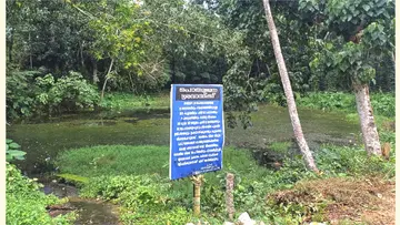മാലിന്യംമൂടിയ കിളിയൂർ കാട്ടുകുളവും കരയിൽ പഞ്ചായത്ത് സ്ഥാപിച്ച മുന്നറിയിപ്പ് ബോർഡ്