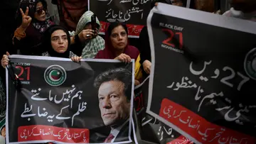party supporters carry a poster of Imran Khan