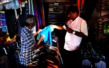 യൂസഫ് കല്ലേക്കാടിന്റെ പാലക്കാട് ടൗൺ സ്റ്റാൻഡിലെ കടയിൽ മൊബൈൽ വെളിച്ചത്തിൽ വസ്ത്രങ്ങൾ തെരയുന്നു