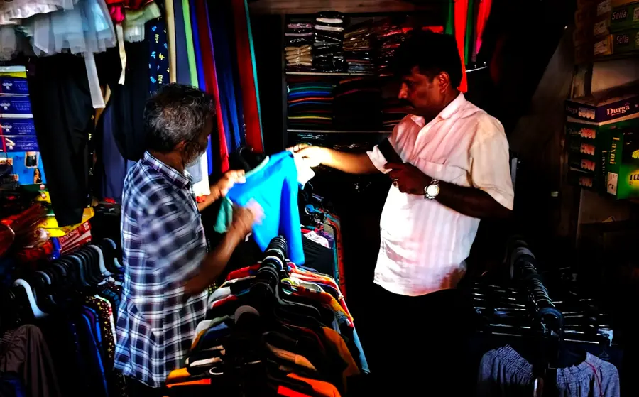 യൂസഫ് കല്ലേക്കാടിന്റെ പാലക്കാട് ടൗൺ സ്റ്റാൻഡിലെ കടയിൽ മൊബൈൽ വെളിച്ചത്തിൽ വസ്ത്രങ്ങൾ തെരയുന്നു