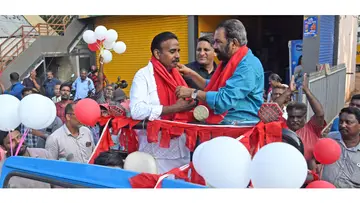 എസ്റ്റേറ്റ് വാർഡ് എൽഡിഎഫ് സ്ഥാനാർഥി  കെ സന്തോഷ് കുമാറിനെ മന്ത്രി വി ശിവൻകുട്ടി ഷാൾ  അണിയിക്കുന്നു 