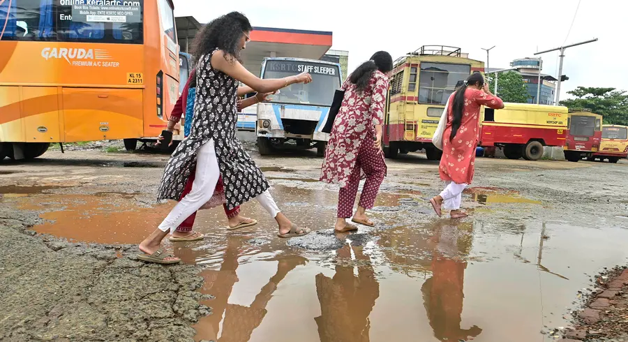 തൃശൂർ കെഎസ്ആർടിസി ബസ് സ്റ്റാൻഡിലെ വെള്ളക്കെട്ടിലൂടെ നടന്നുപോകുന്ന യാത്രക്കാർ ഫോട്ടോ/ സുരേന്ദ്രൻ മടിക്കൈ