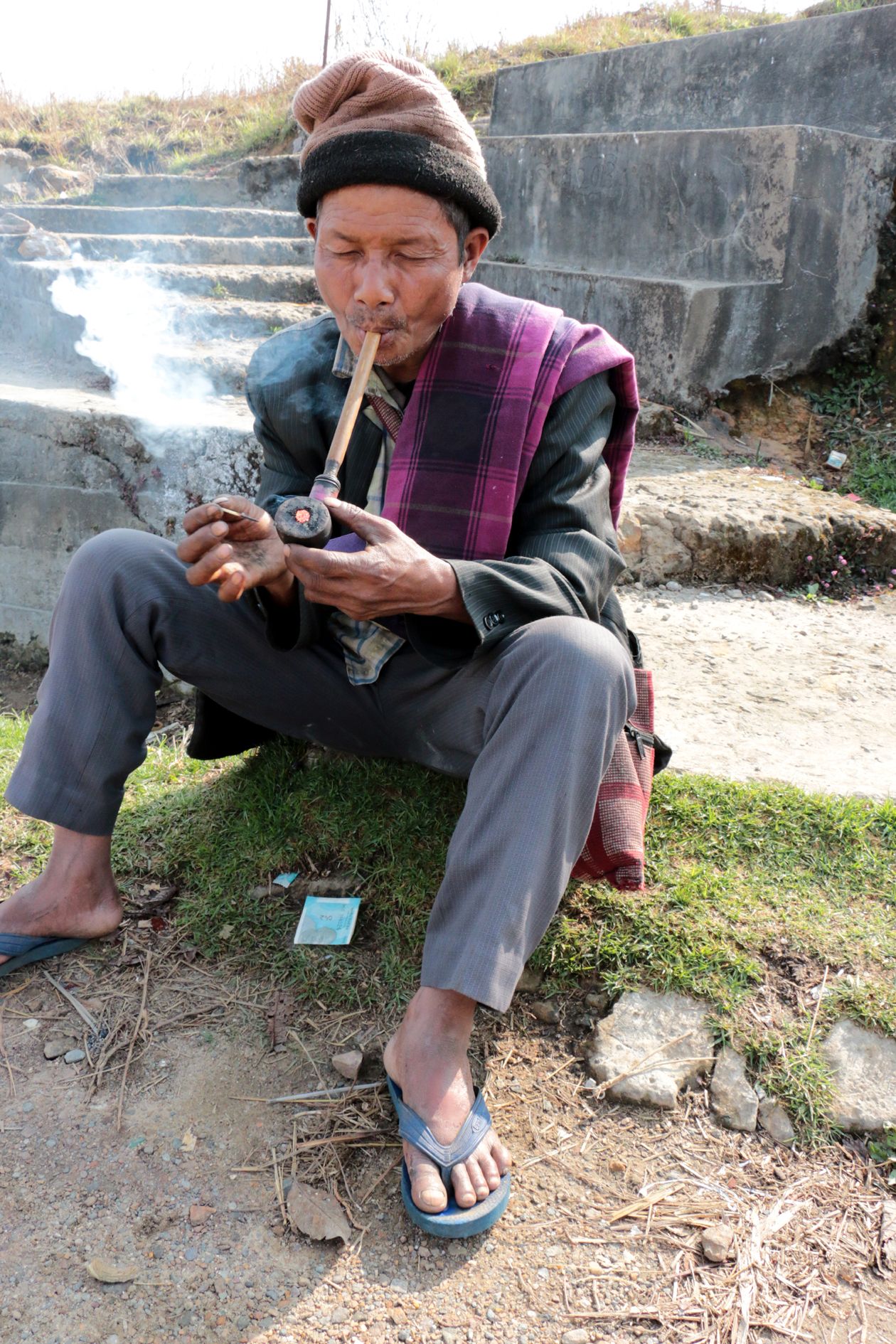  വഴിയരികിലിരുന്ന്‌ നാടൻ പൈപ്പ്‌ വലിക്കുന്നയാൾ 