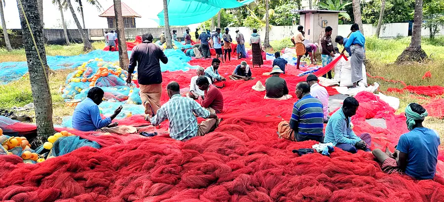 കേടായ വലയുടെ അറ്റകുറ്റപ്പണി നടത്തുന്ന മത്സ്യത്തൊഴിലാളികൾ 