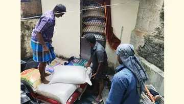 വന്യക്കോടിനടുത്ത് വാടകവീട്ടിൽനിന്ന് പിടികൂടിയ റേഷനരി മാറ്റുന്നു